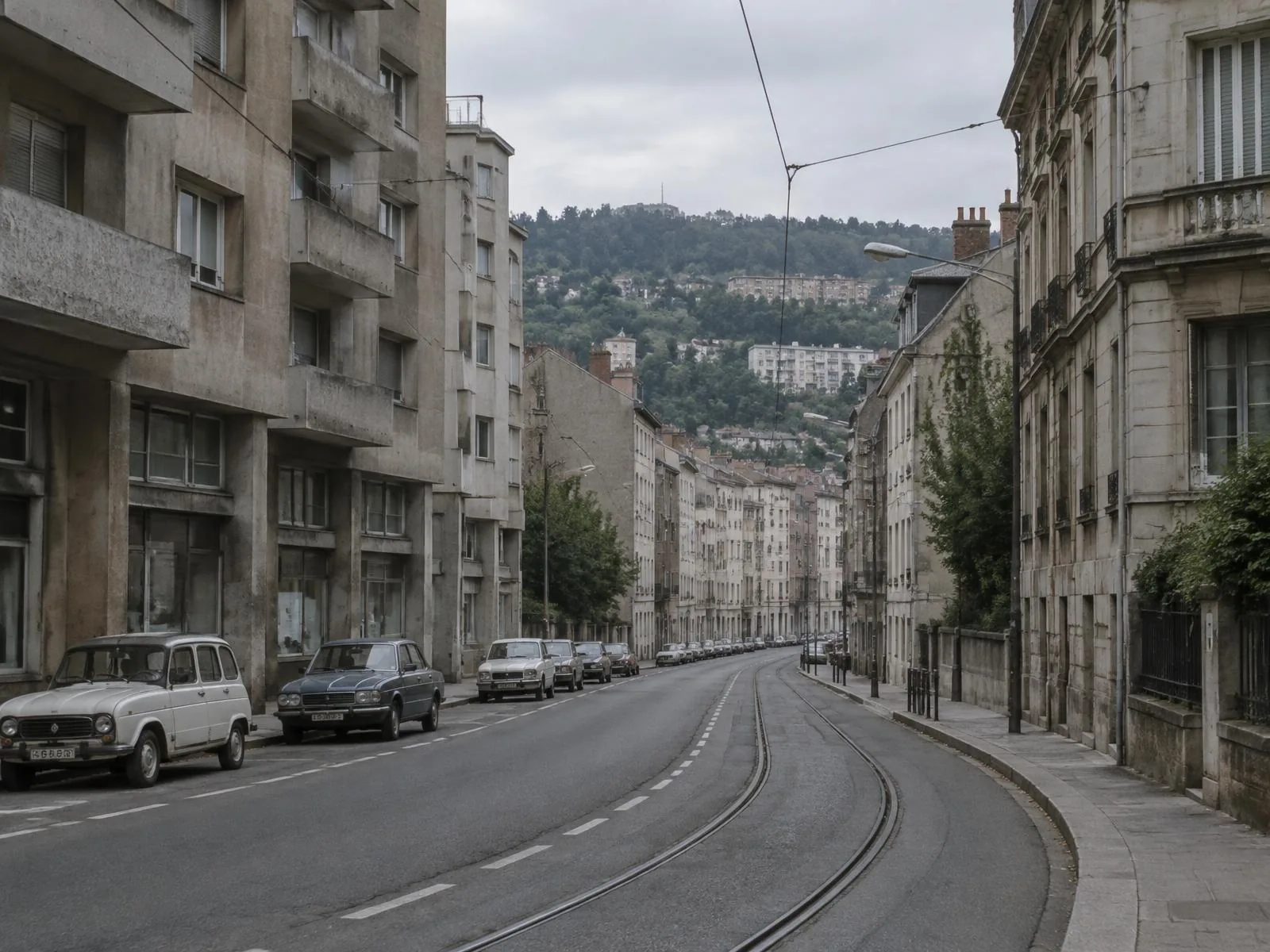 Rue de Saint-Etienne avec rails de tramway et collines en arrière-plan